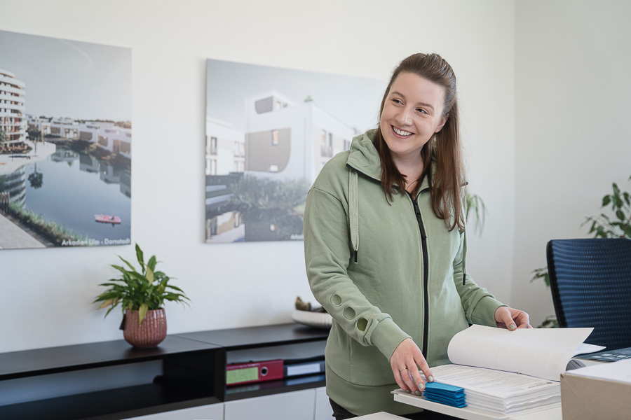 Mitarbeiterin blättert in Ordner im Büro von green:balance – Energieberatung Weißenhorn  